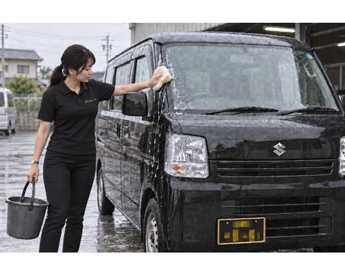 黒い軽バンを洗車するアミスの女性スタッフのイメージ