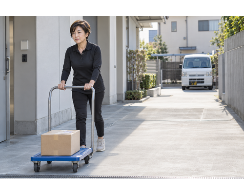 荷物を載せた台車を押す女性