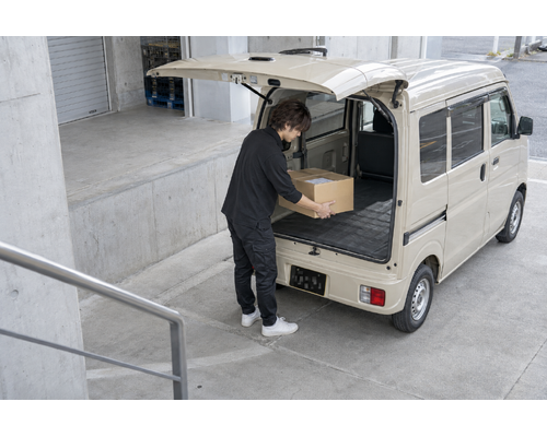 チャーター便の荷物を積む男性ドライバー