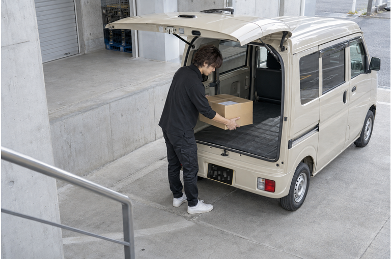 チャーター便の荷物を積む男性ドライバー