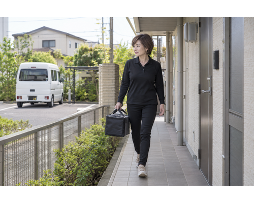 個人宅へお弁当を運ぶ女性