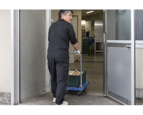 建物内へ荷物を搬入する男性