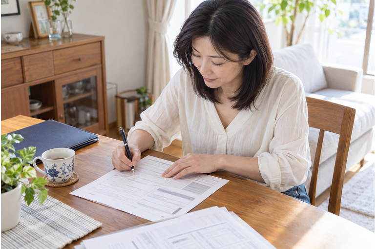 開業の書類を記入する私服の女性