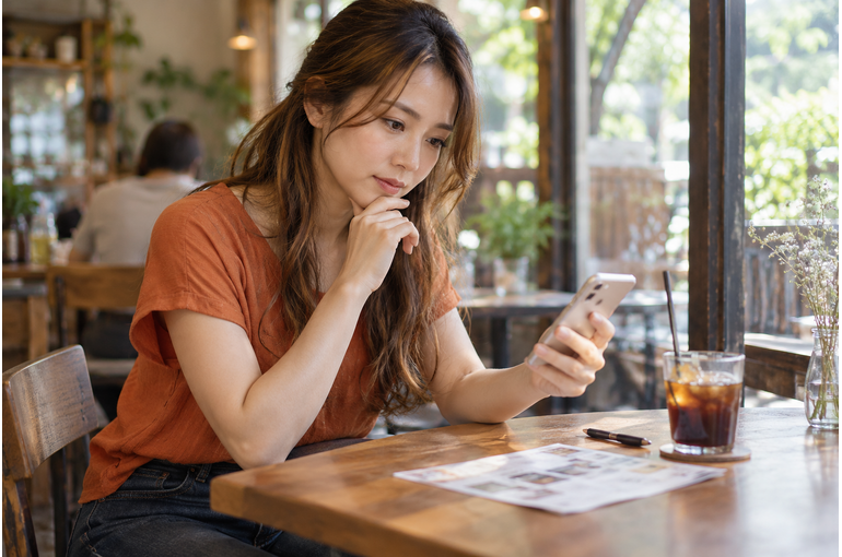 副業の募集内容をスマートフォンで確認する女性