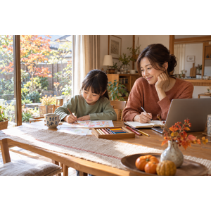 秋の自宅で副業の情報を調べる40代のお母さんと隣で絵を描く子ども