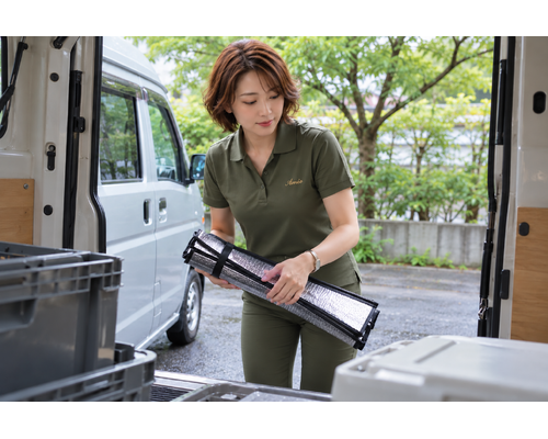 明るい季節の仕事の合間に車内用品を整える女性