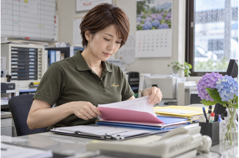 月末に配送の相談資料を整理する女性