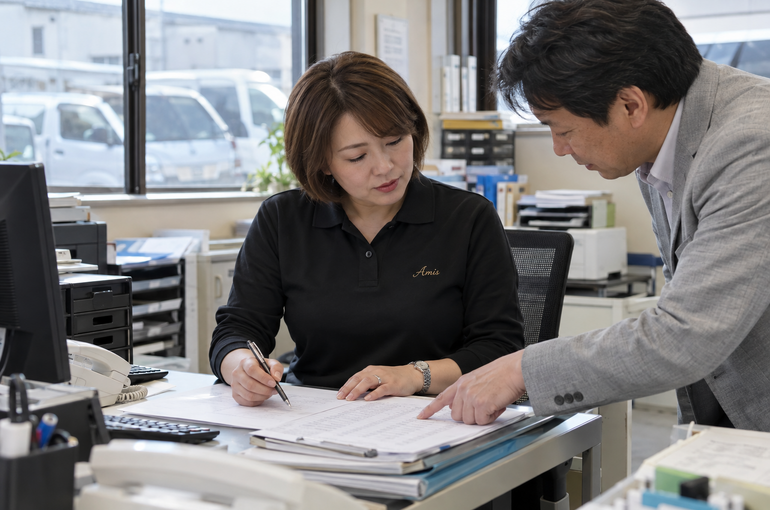 配送内容の書類を確認する女性担当者と私服の男性相談者
